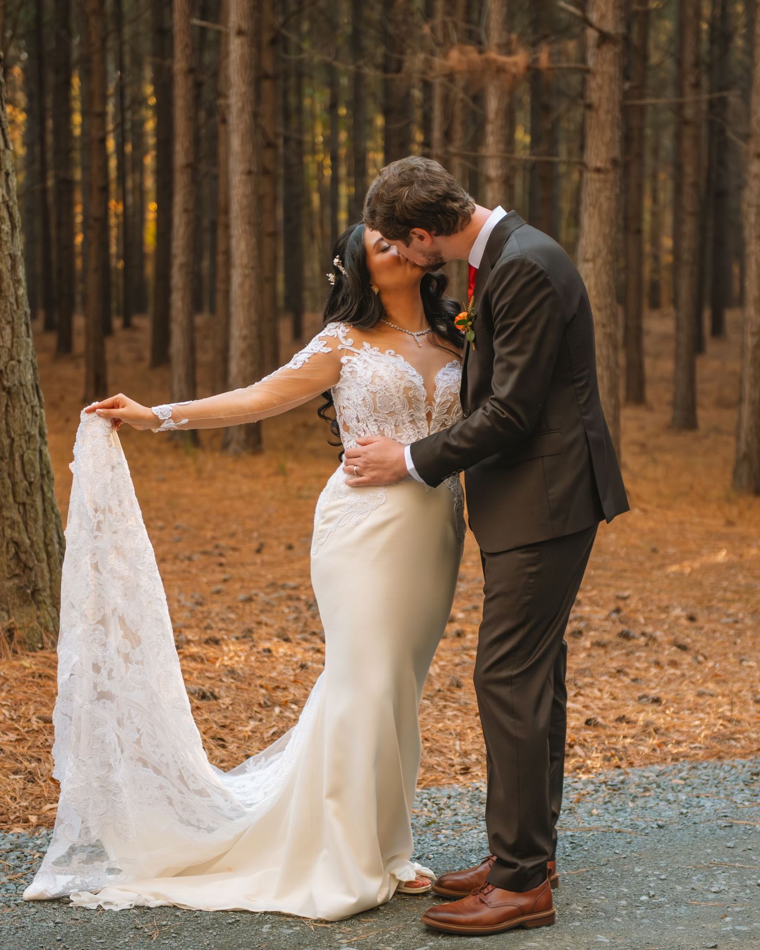 Bride and groom embracing in a wooded setting during a romantic outdoor wedding portrait.