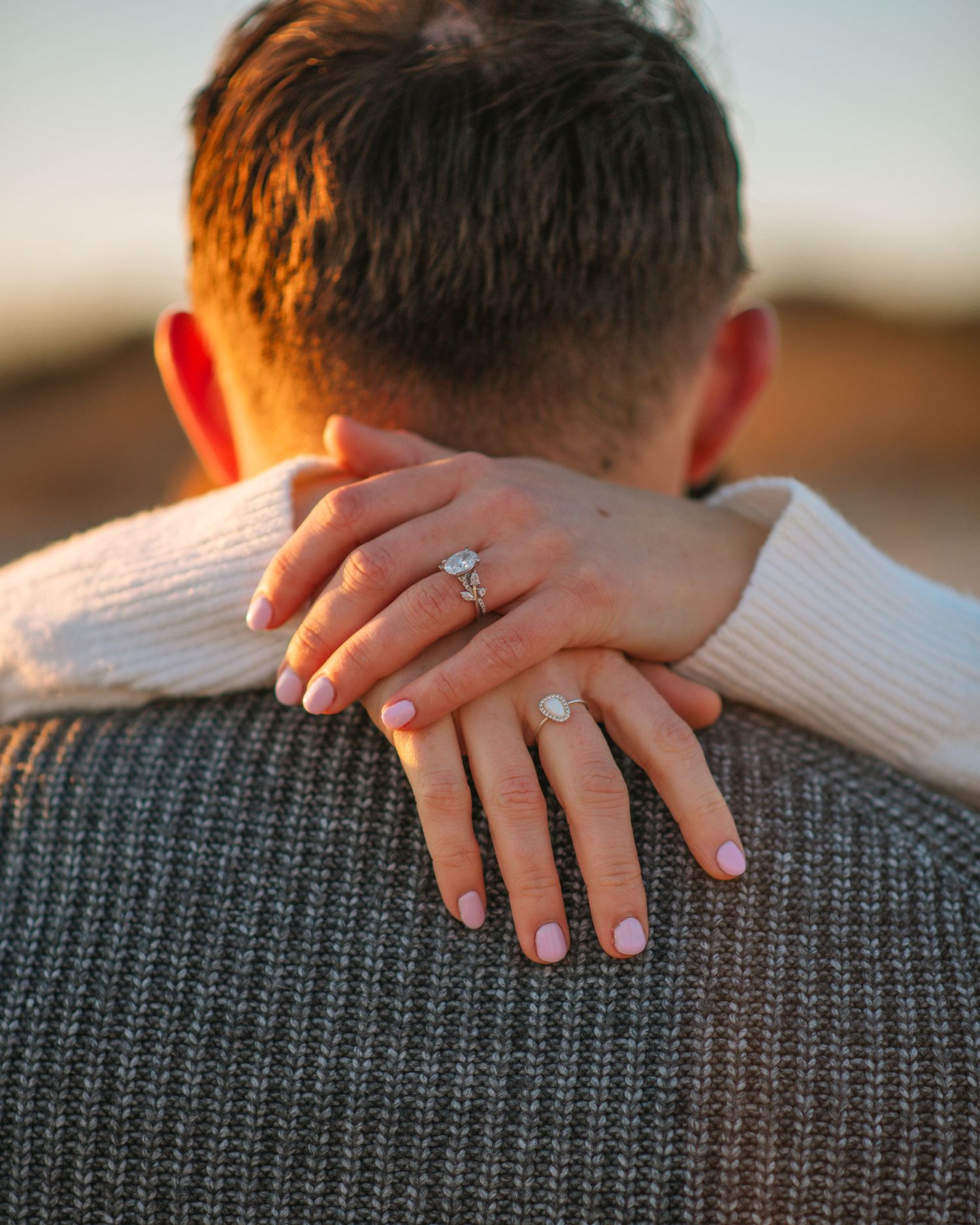 Close-up of engagement ring on hand resting on partner’s shoulder during beach session. on Sullivans Island, Charleston SC