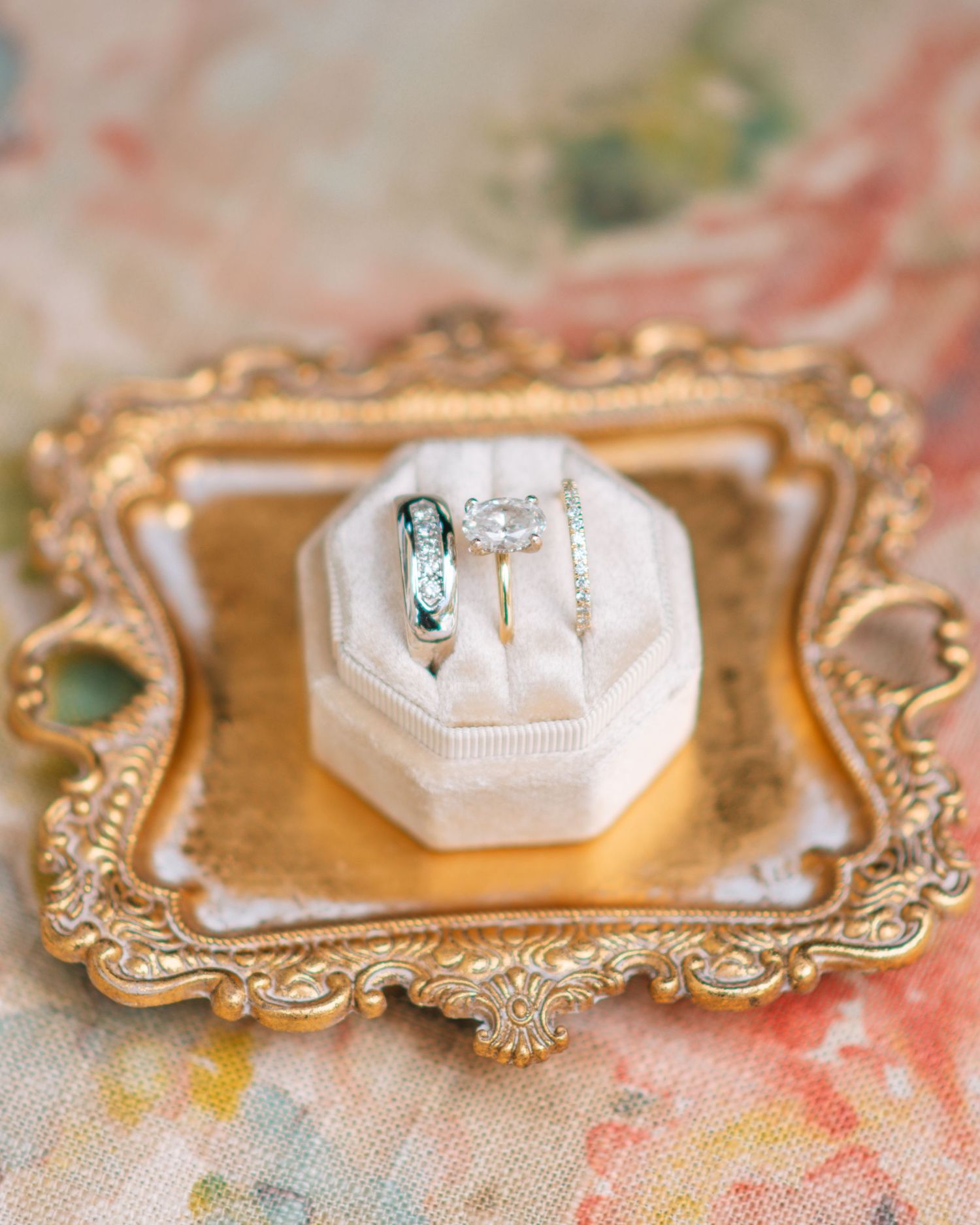 Wedding rings displayed in an elegant box on a decorative tray during bridal detail photos.