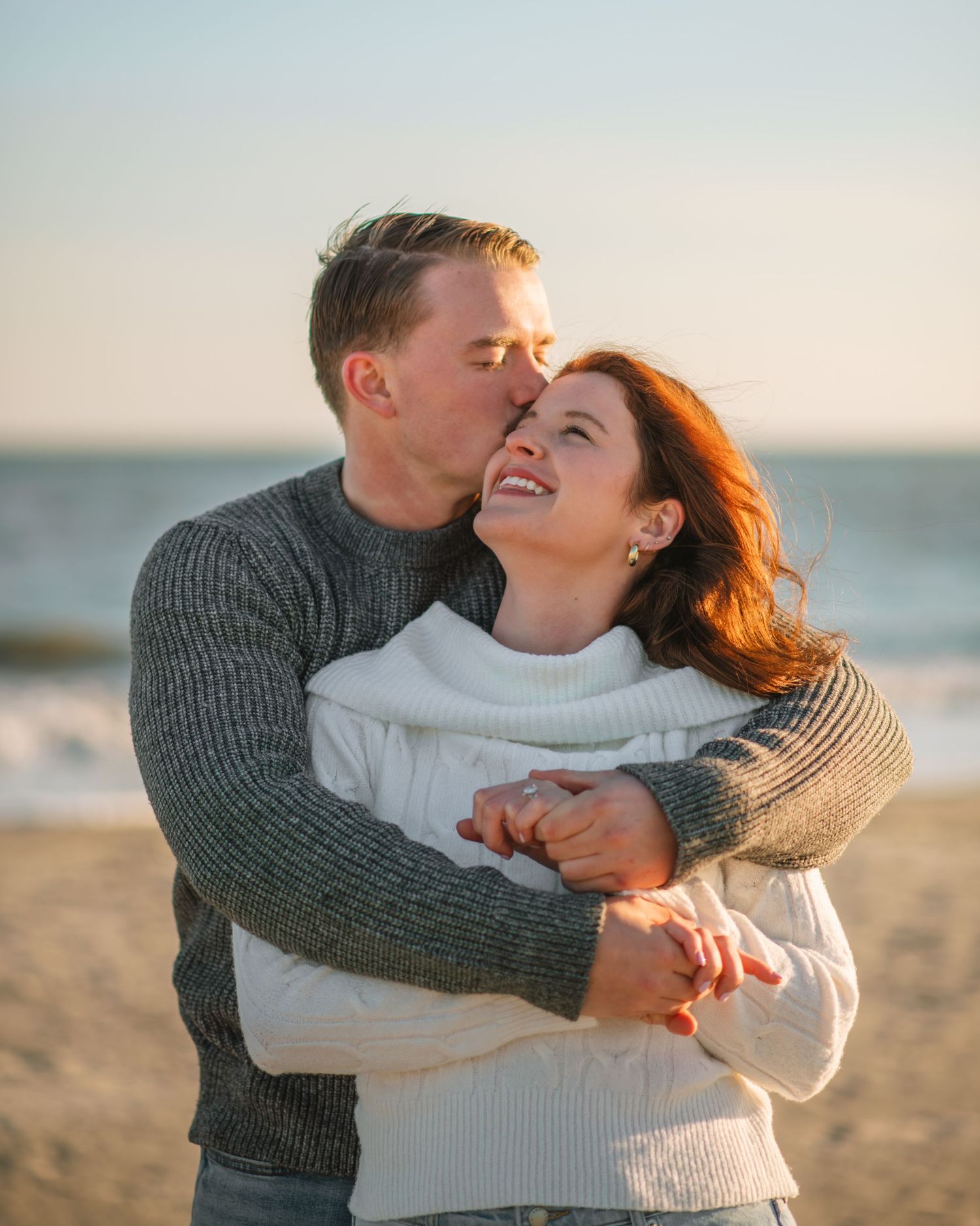 Couple embracing and smiling together during a romantic beach sunset session. on Sullivans Island, Charleston SC