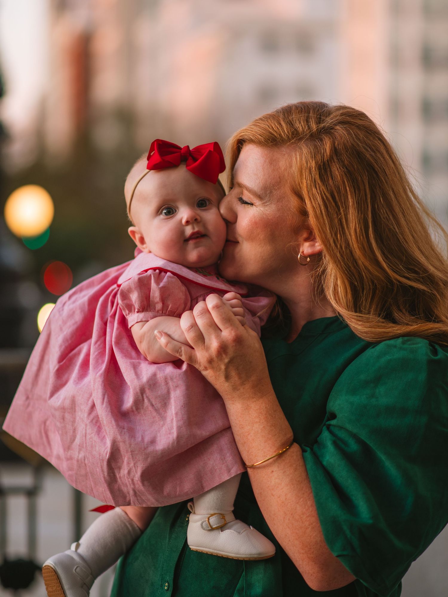 Mother kissing baby girl on the cheek during a golden hour family session at the South Carolina State House