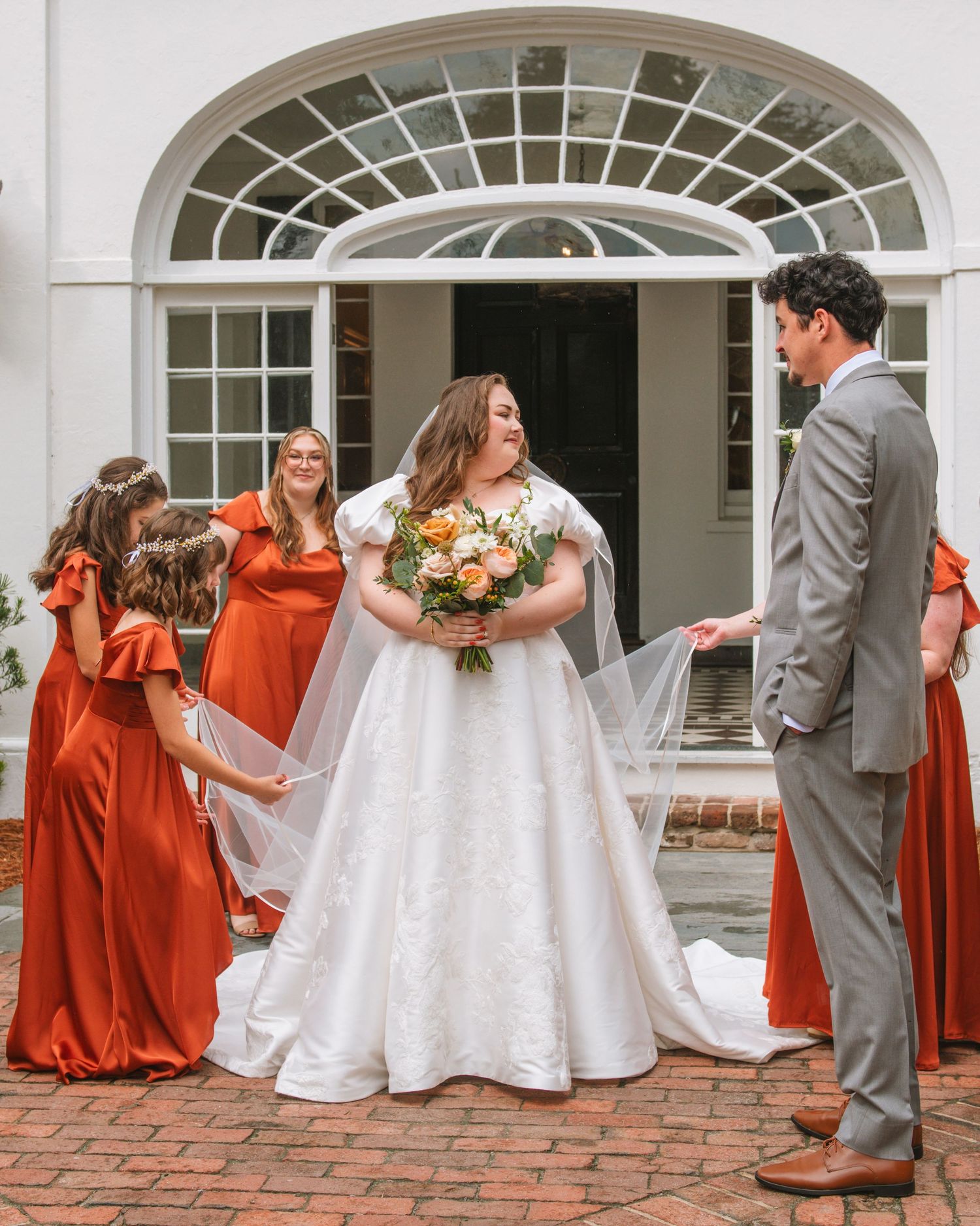 Bride and bridesmaids gathered together before ceremony during a joyful wedding moment.
 At Lowndes Grove Charleston SC