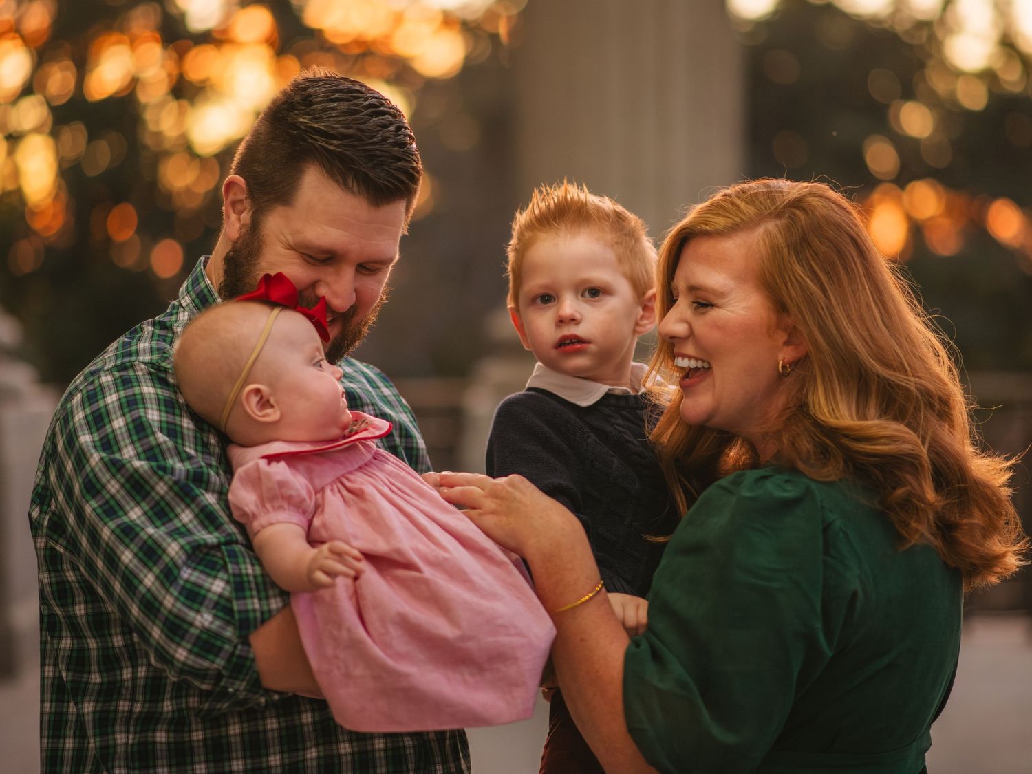 Parents holding their children close during a warm sunset family moment at the South Carolina State House