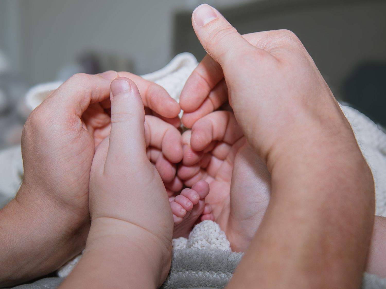 Close-up of parents holding newborn baby hands during a heartfelt lifestyle newborn session