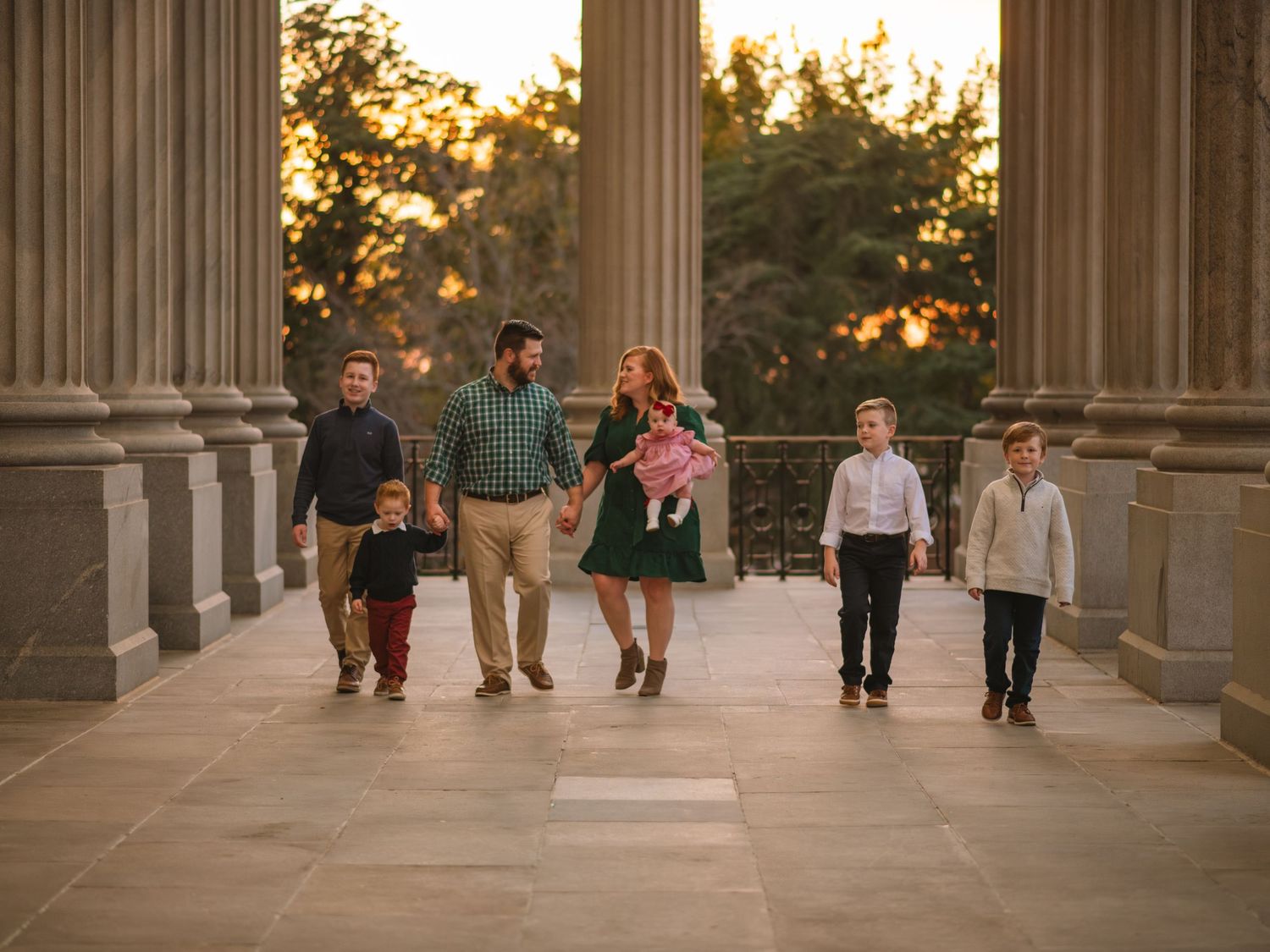 Family walking together between columns during golden hour at the South Carolina State House
