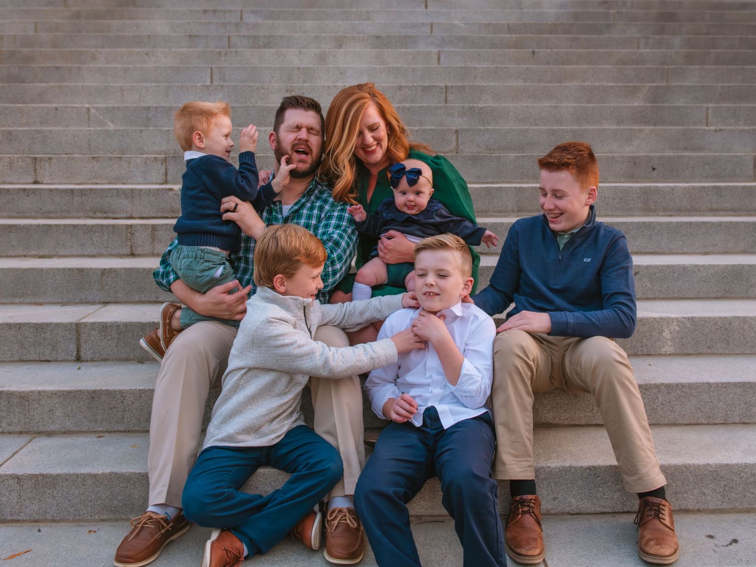 Family laughing together on steps during a playful outdoor family session on the step of South Carolina State House