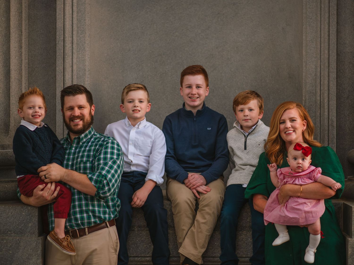 Family of six posed together in a classic portrait during a studio-style family session at the South Carolina State House