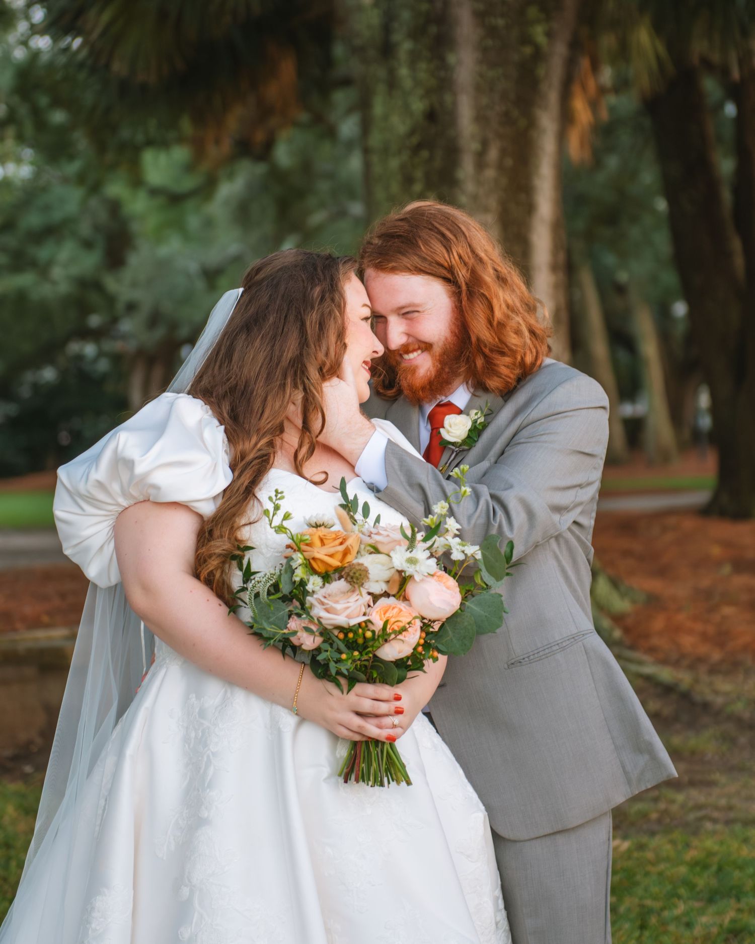 Bride and groom holding bouquet together during a romantic outdoor wedding portrait. At Lowndes Grove Charleston SC