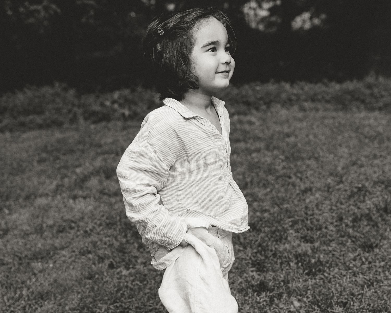 Black and white portrait of a young child looking back while walking outdoors, Woodbridge, CT family session