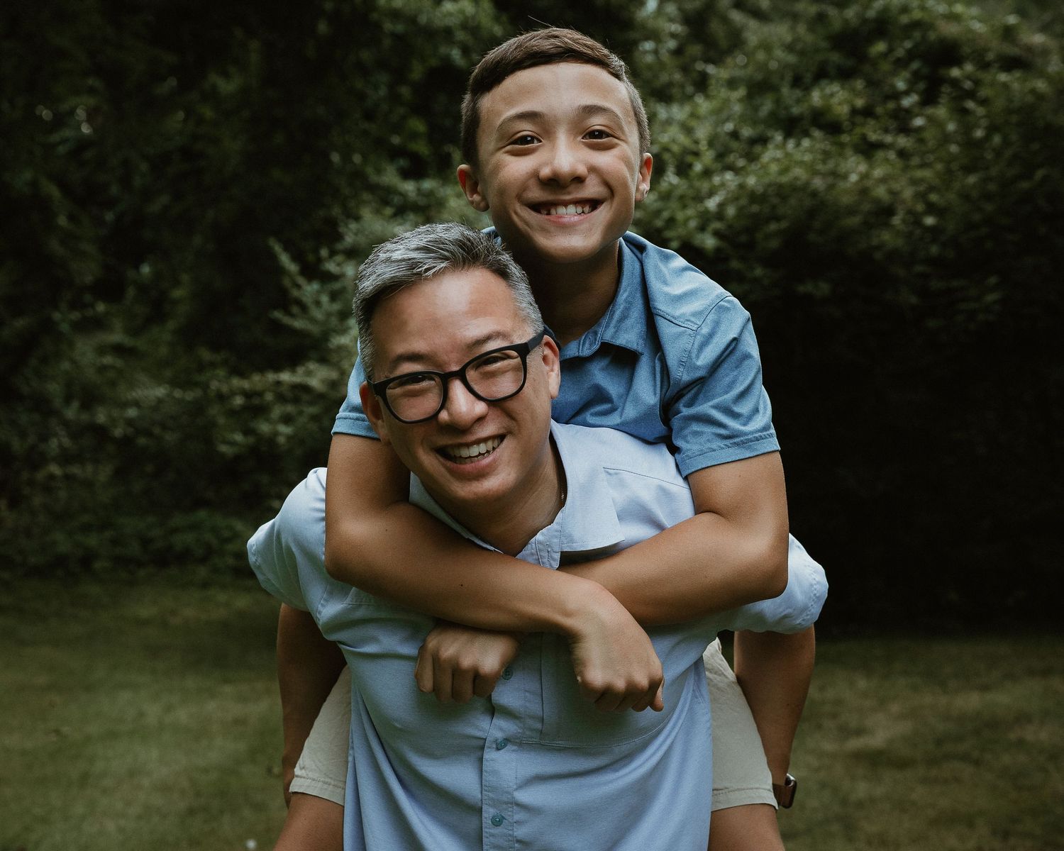 Father giving his son a piggyback ride during a family portrait session in Woodbridge, CT
