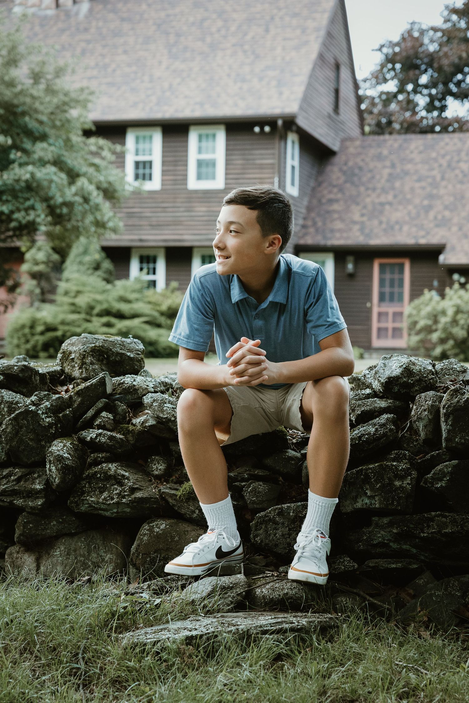 Teenage boy portrait seated on a stone wall from a Woodbridge CT family photography session