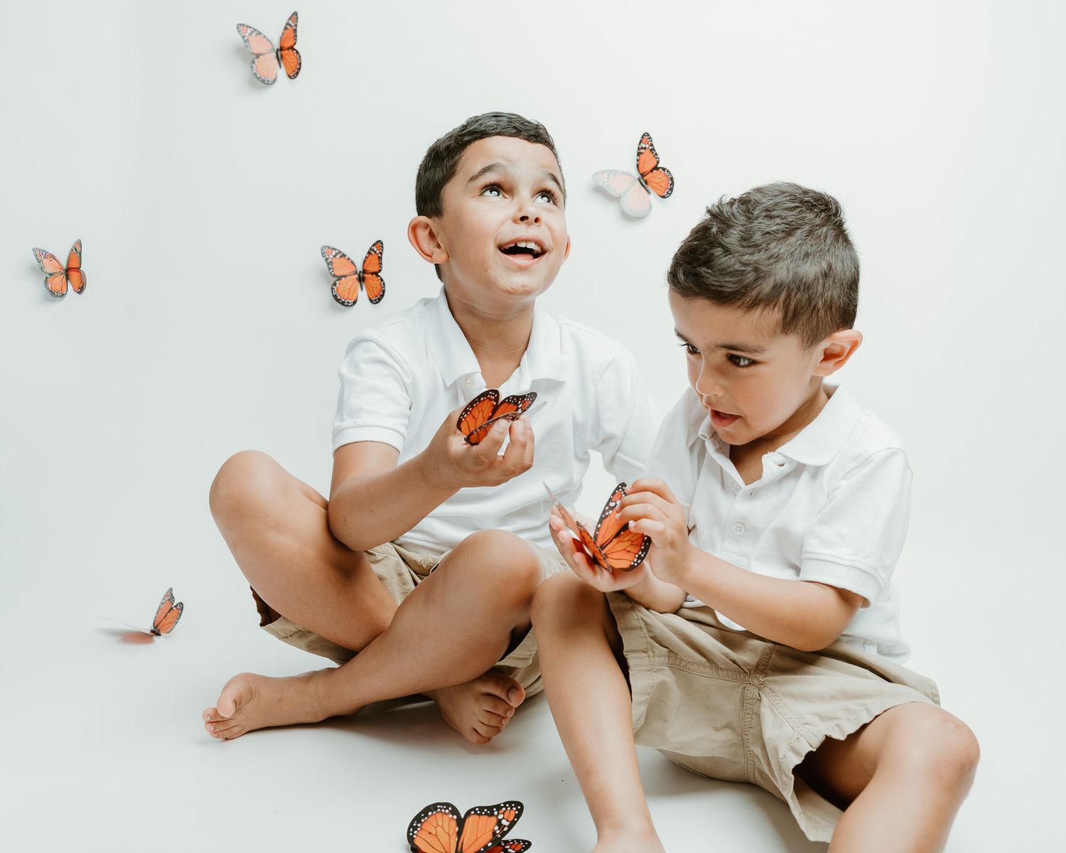 Two brothers looking up at butterflies together, studio session, Connecticut children's photography
