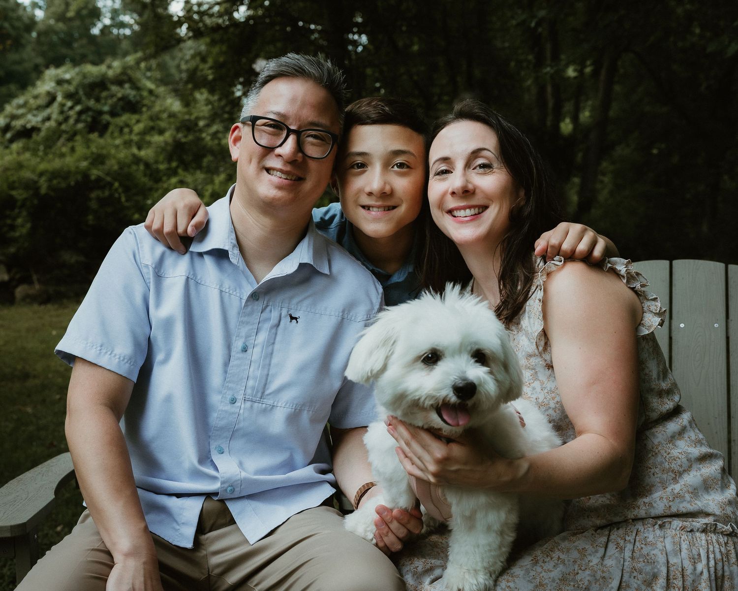 Family photography session in Woodbridge CT with parents, their teenage son, and their dog seated together outdoors