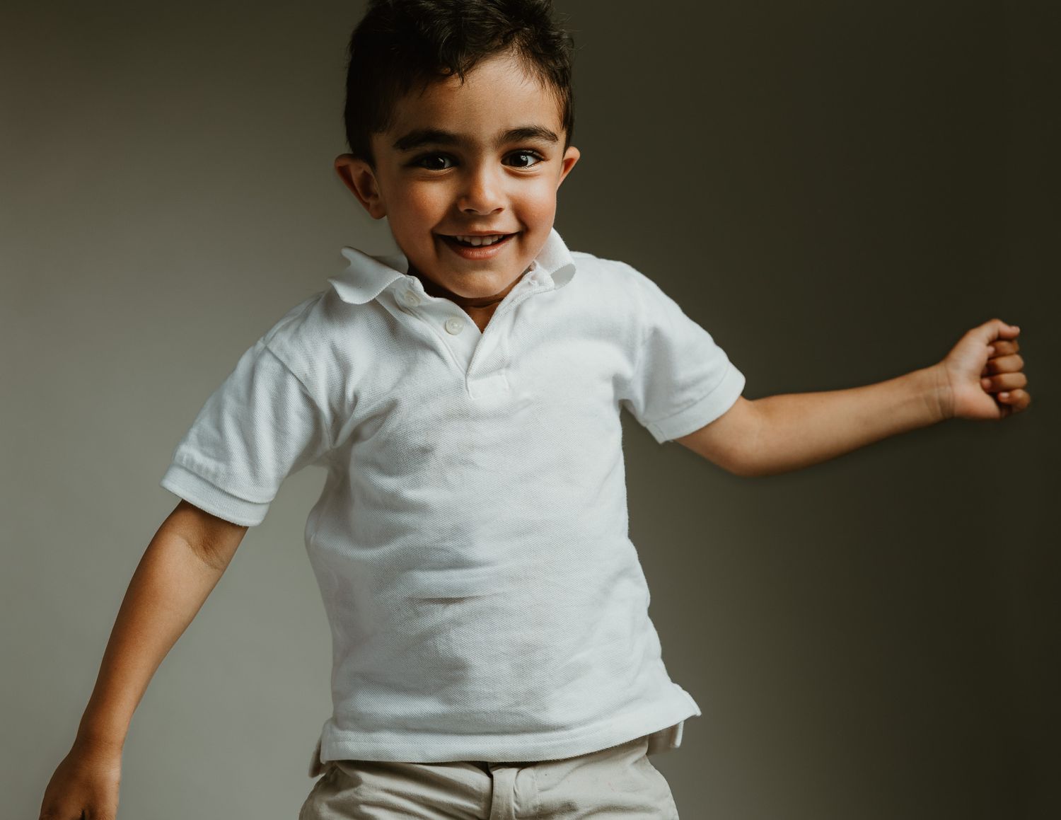 Smiling boy in studio portrait mid-motion, Connecticut children's photography