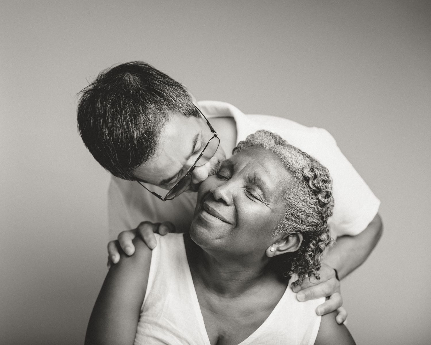 Husband kissing wife's forehead in black and white portrait, senior couple embrace, Connecticut family photography