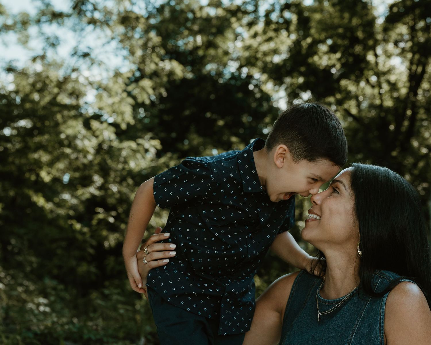 Mother nuzzling her son's shoulder outdoors, candid family portrait Woodbridge Connecticut