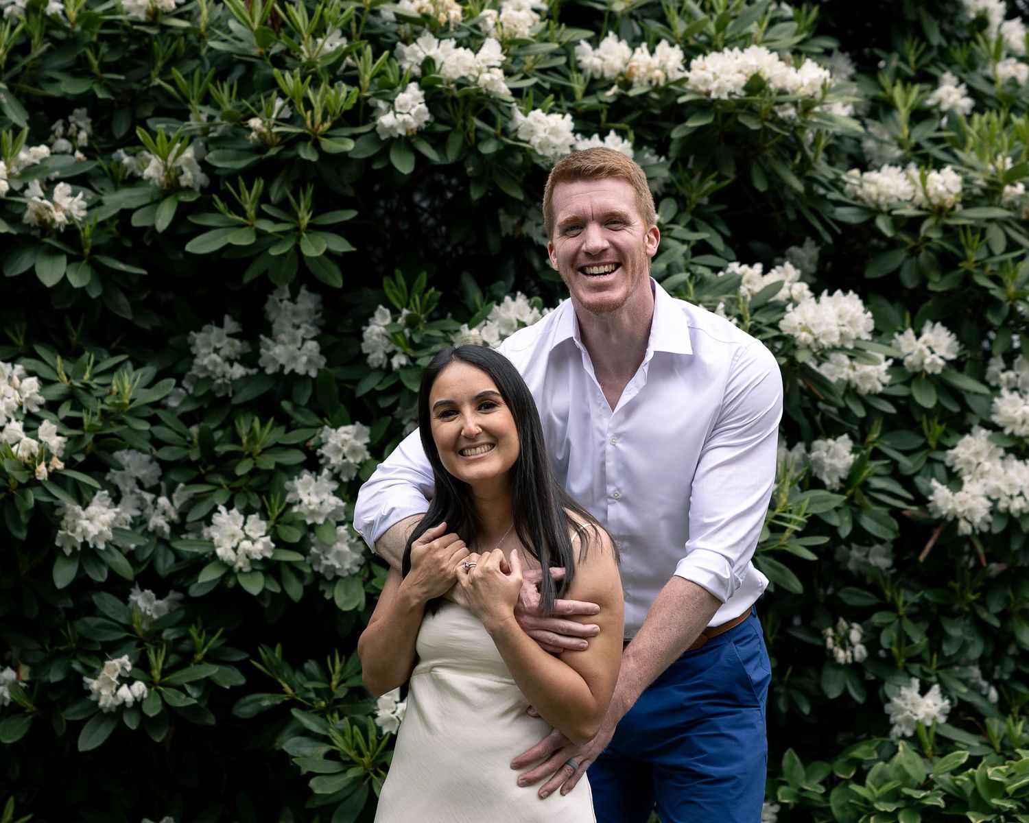 Couple laughing together among flowering bushes, Connecticut couples photography session