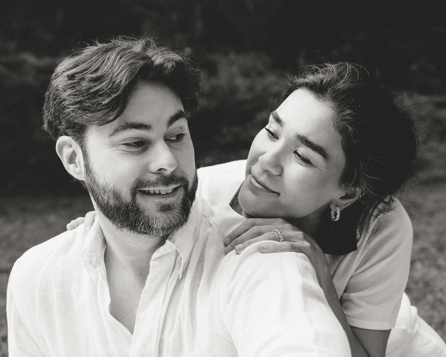 Black and white portrait of a couple, her head resting on his shoulder, outdoor family session in Woodbridge, CT