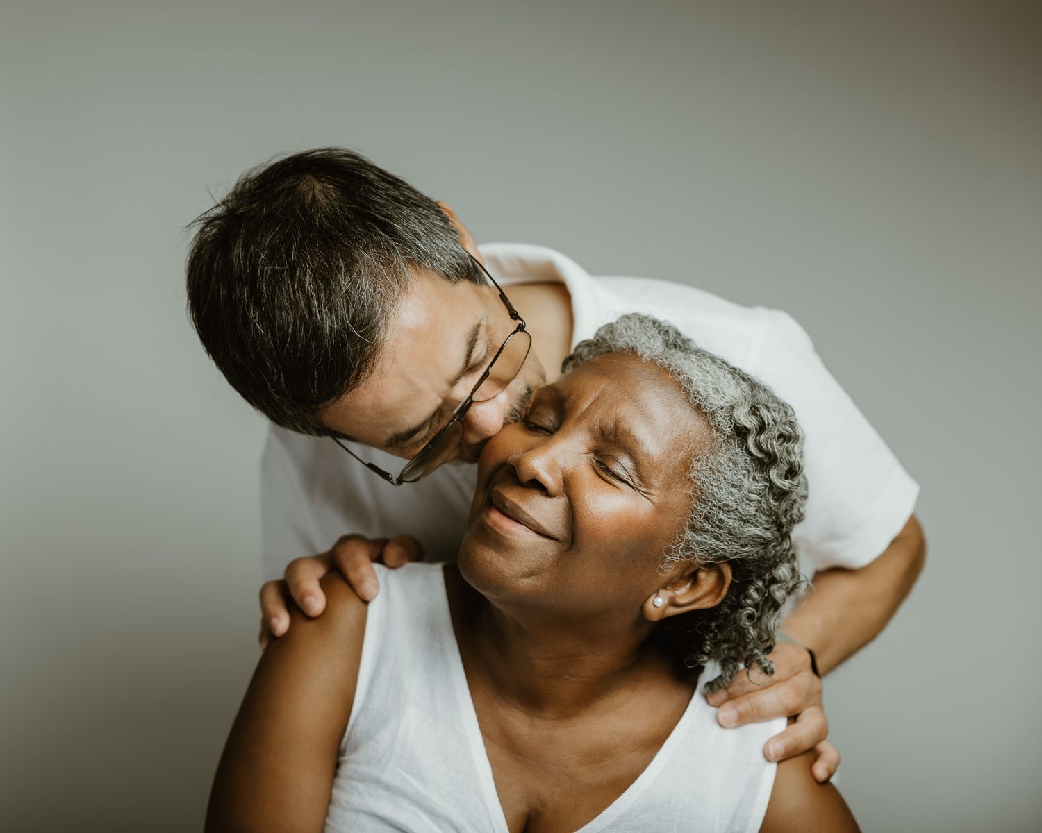Husband embracing his wife from behind in warm studio family portrait, Woodbridge CT