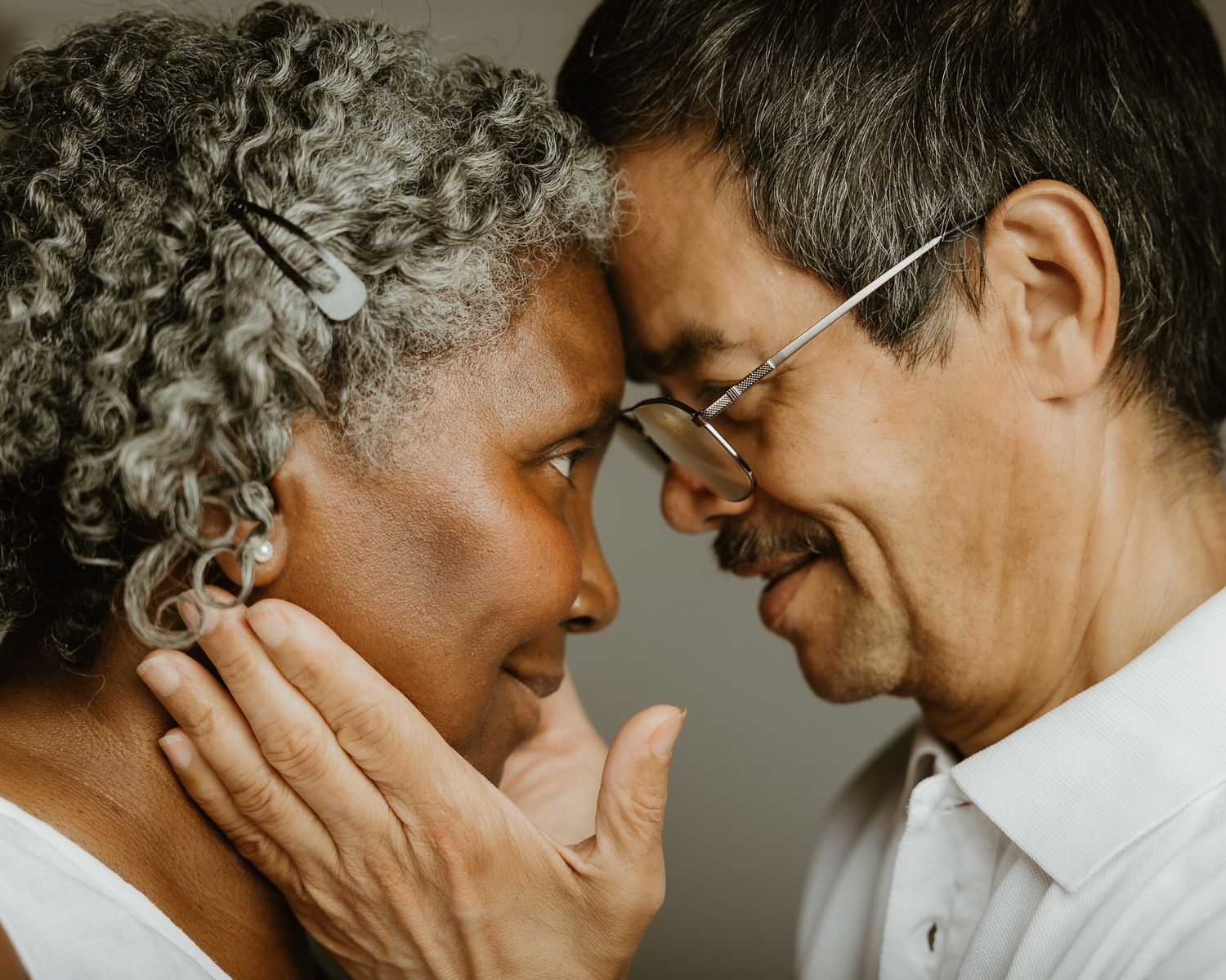Elderly couple in intimate forehead-to-forehead embrace, studio portrait by Woodbridge CT photographer
