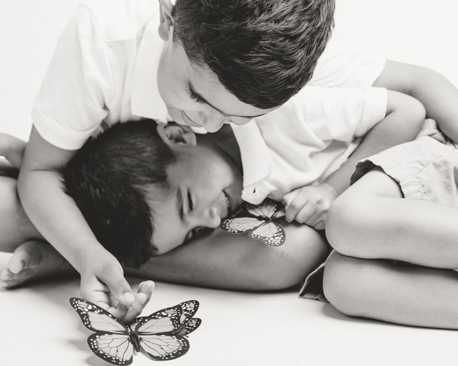 Brothers playing with a butterfly together in studio session, Connecticut children's photography
