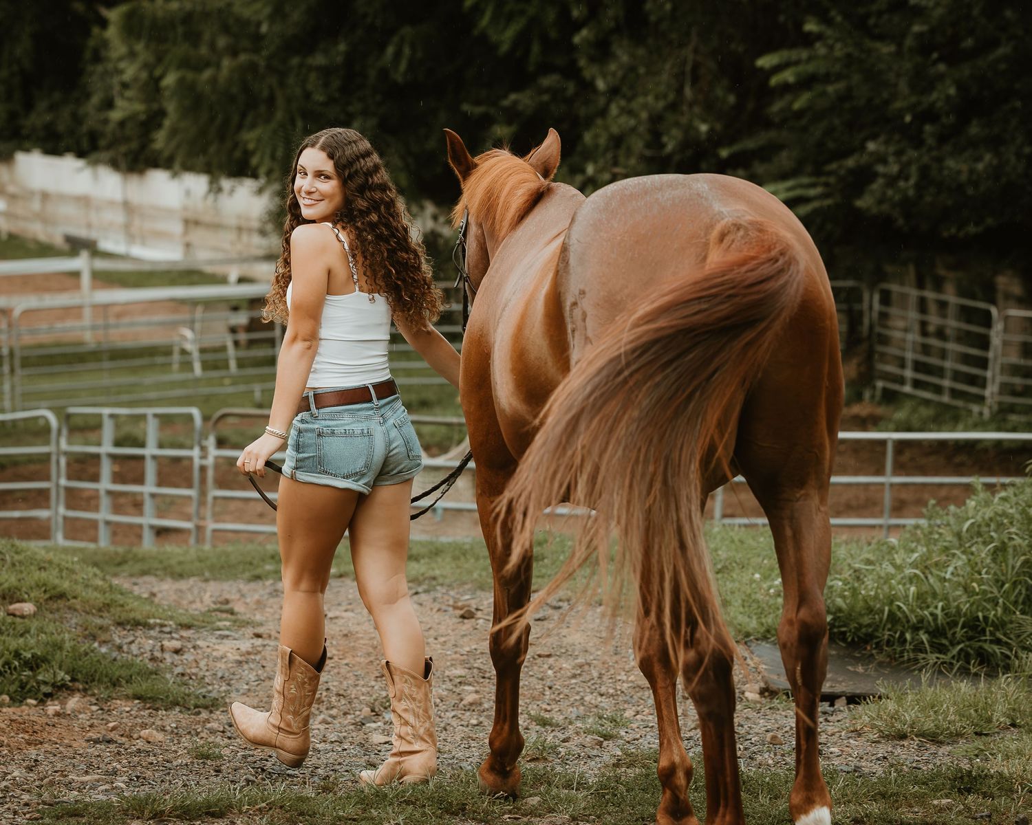 Young equestrian walking beside her horse during a relaxed horse and rider portrait session in Connecticut.