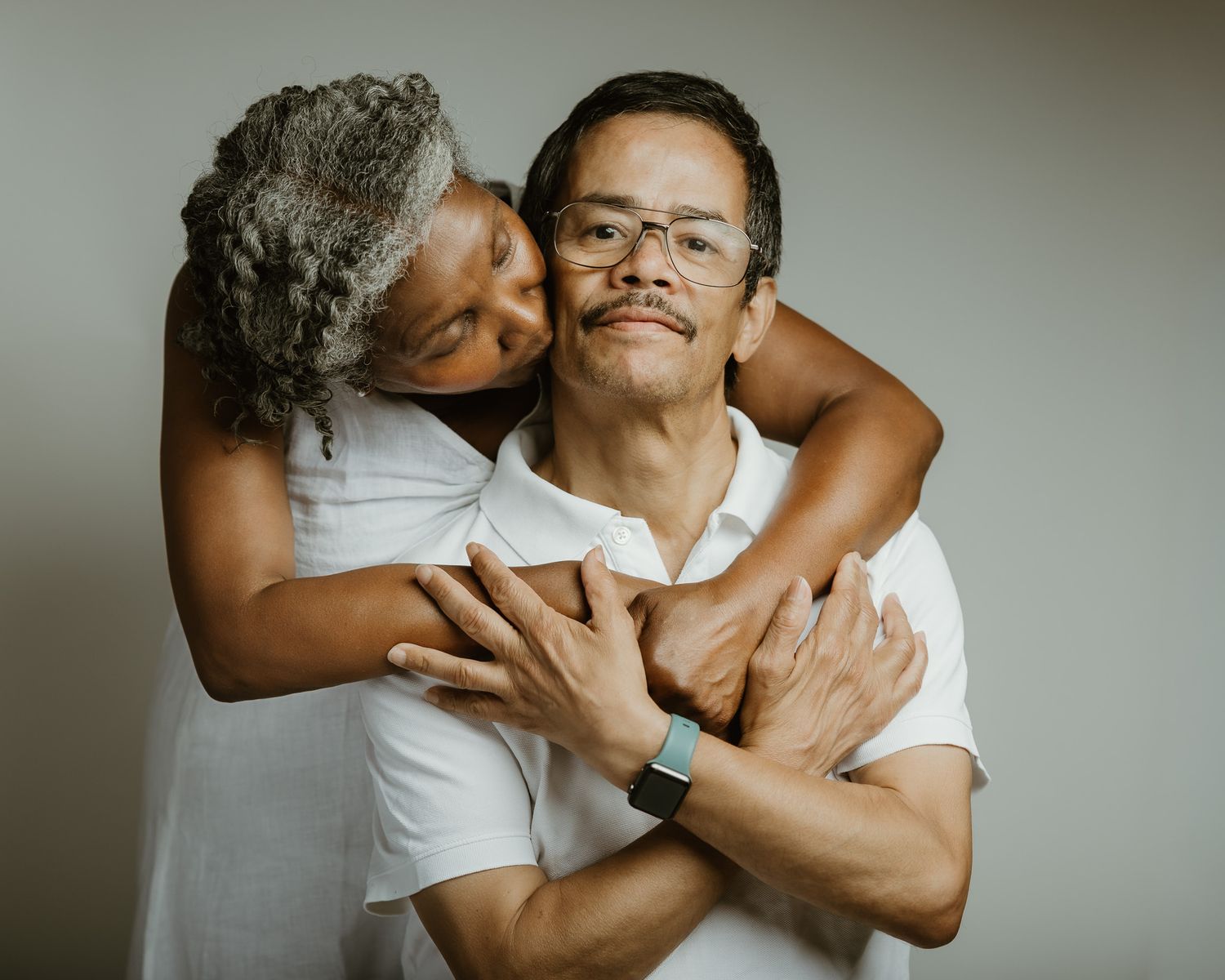 Wife kissing husband's cheek in warm studio couple portrait, Woodbridge CT photographer