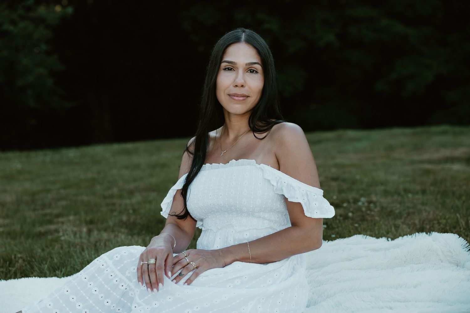 Outdoor portrait of Christina seated on a blanket in a white dress, editorial femme photography in Connecticut