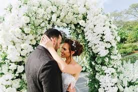 Wedding couple at floral arch, editorial wedding photography from Manhattan Bride magazine