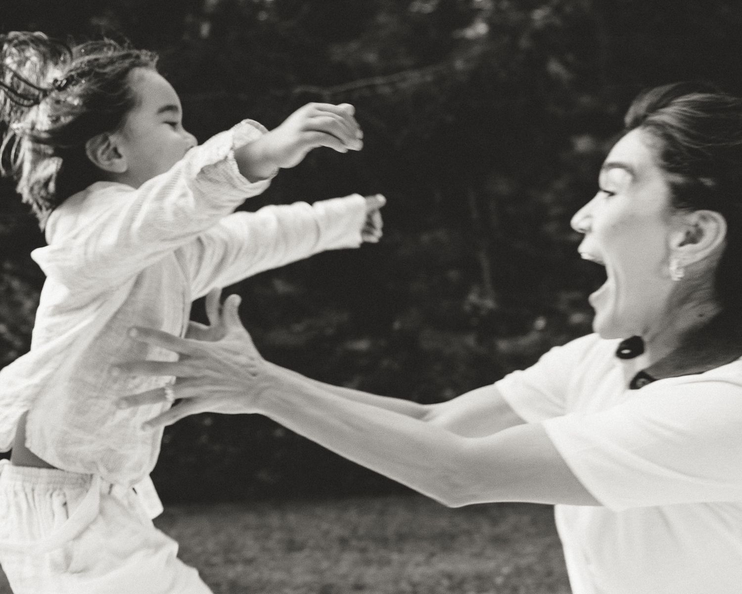 Black and white candid moment of mother and child playing outdoors, Woodbridge, CT family photography