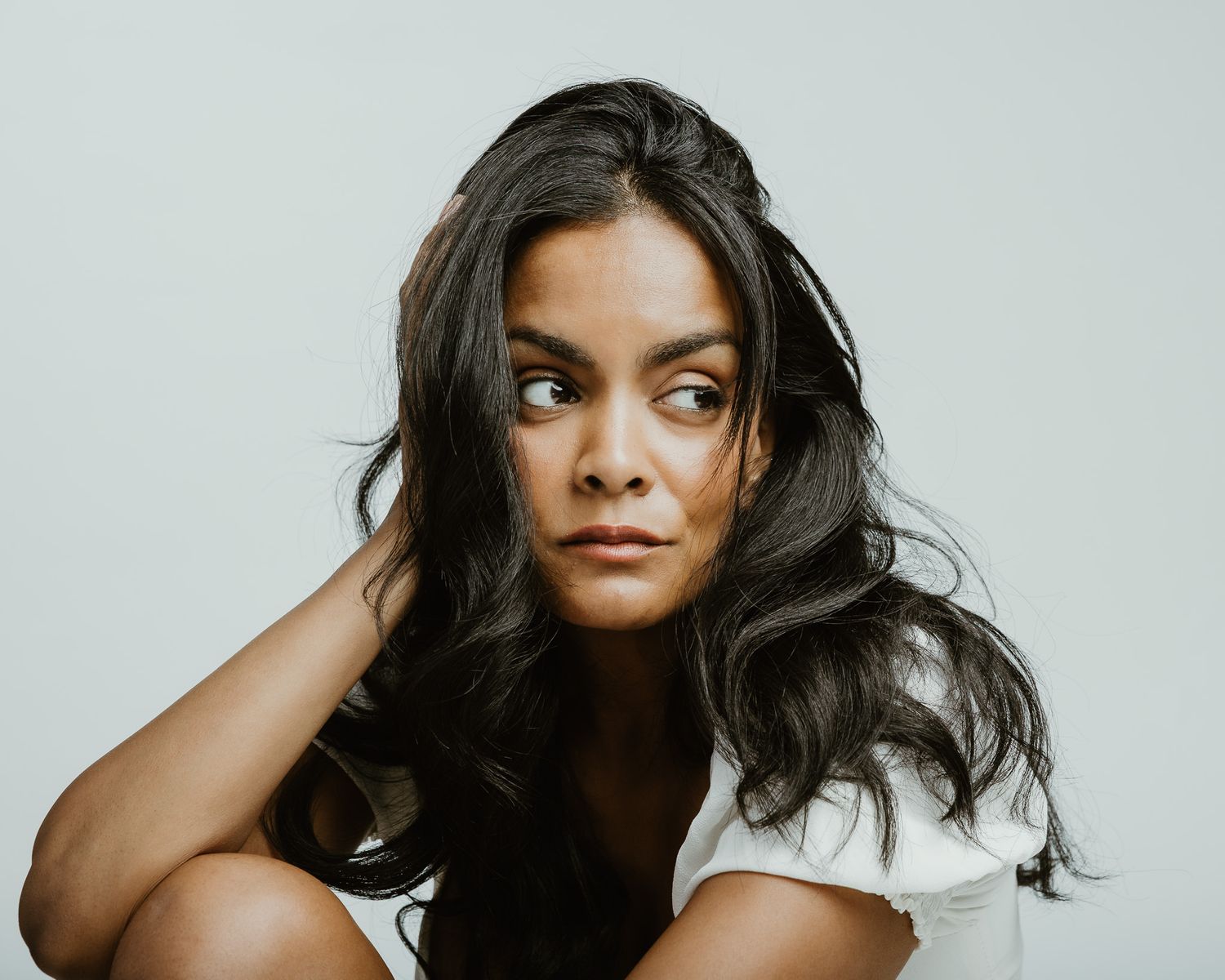Editorial portrait with hand in hair, side profile