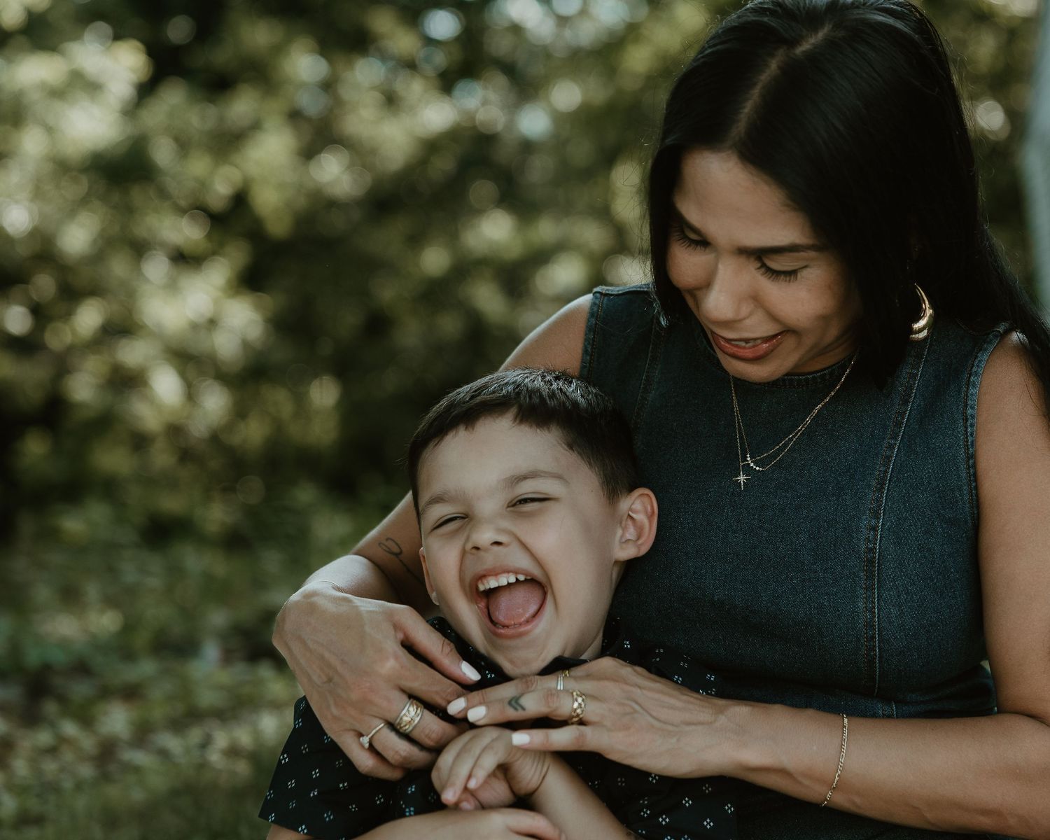 Mother laughing with her son nestled against her outdoors, New Haven County CT family portrait