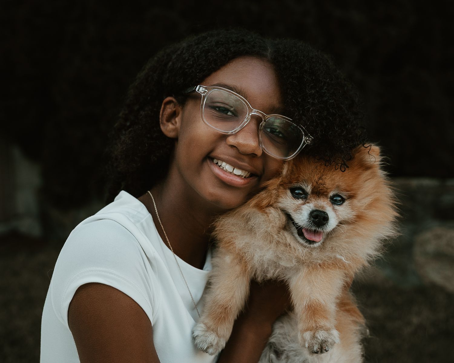 Girl smiling with the family's Pomeranian outdoors, Connecticut family photography session