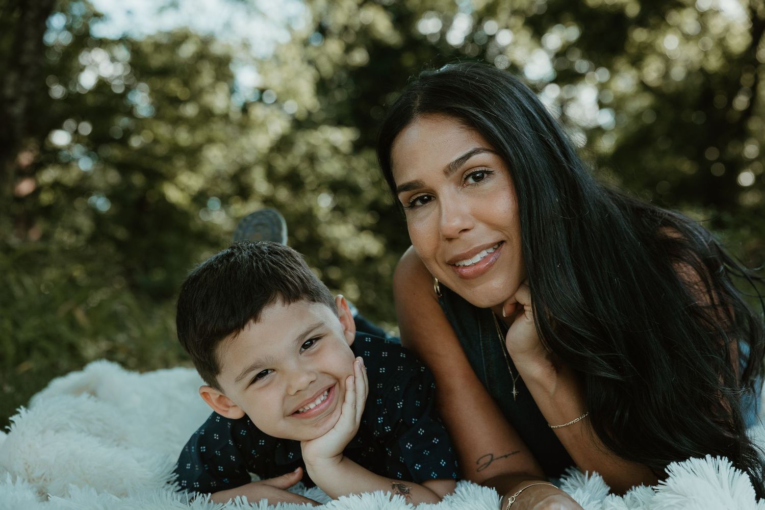Mother and son lying together outdoors, both smiling, family photographer Woodbridge CT