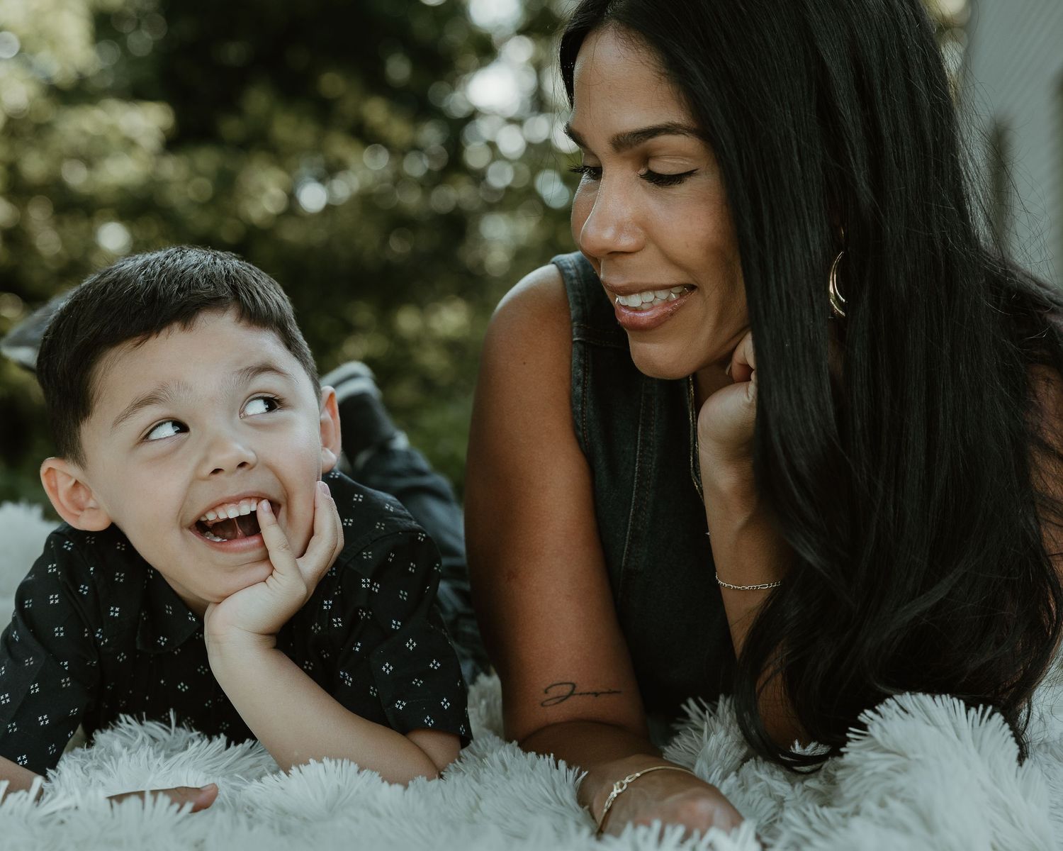 Mother and son lying together on a blanket outdoors, candid family portrait New Haven County CT