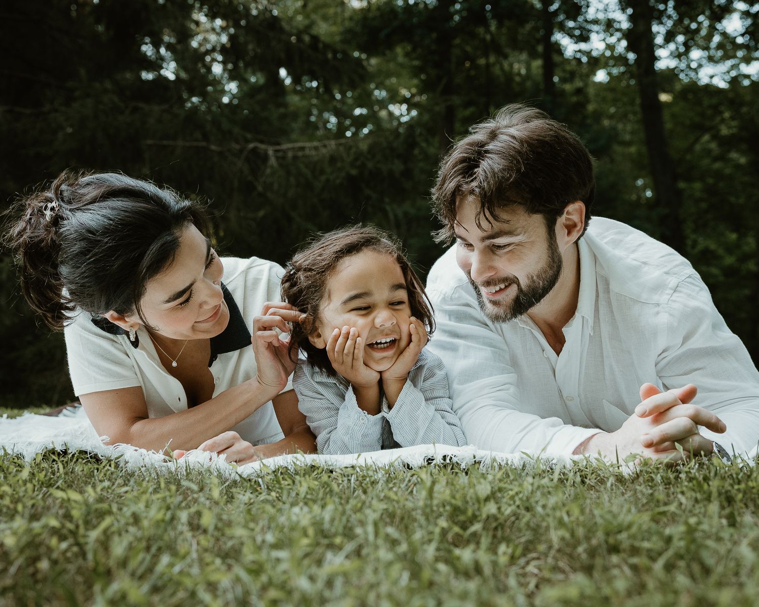 Family of three lying together on a blanket outdoors, Woodbridge, CT family portrait session