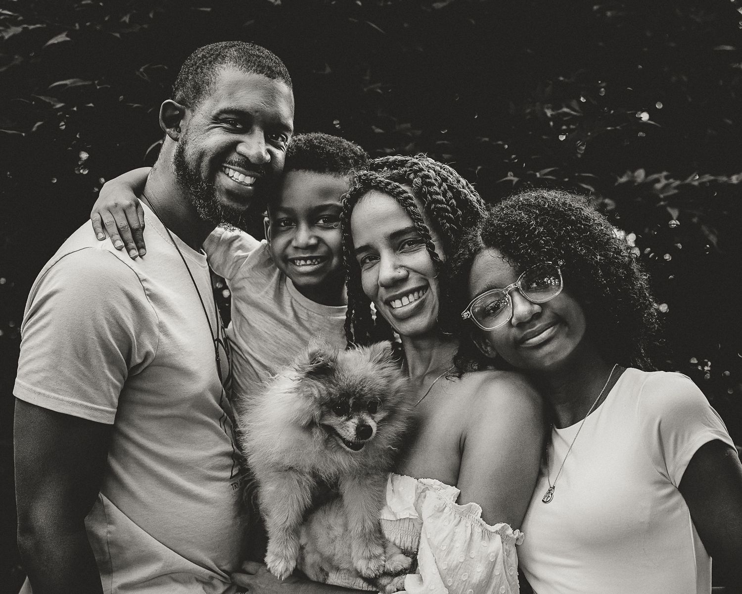 Black and white family portrait of four with their Pomeranian, Connecticut family portrait session