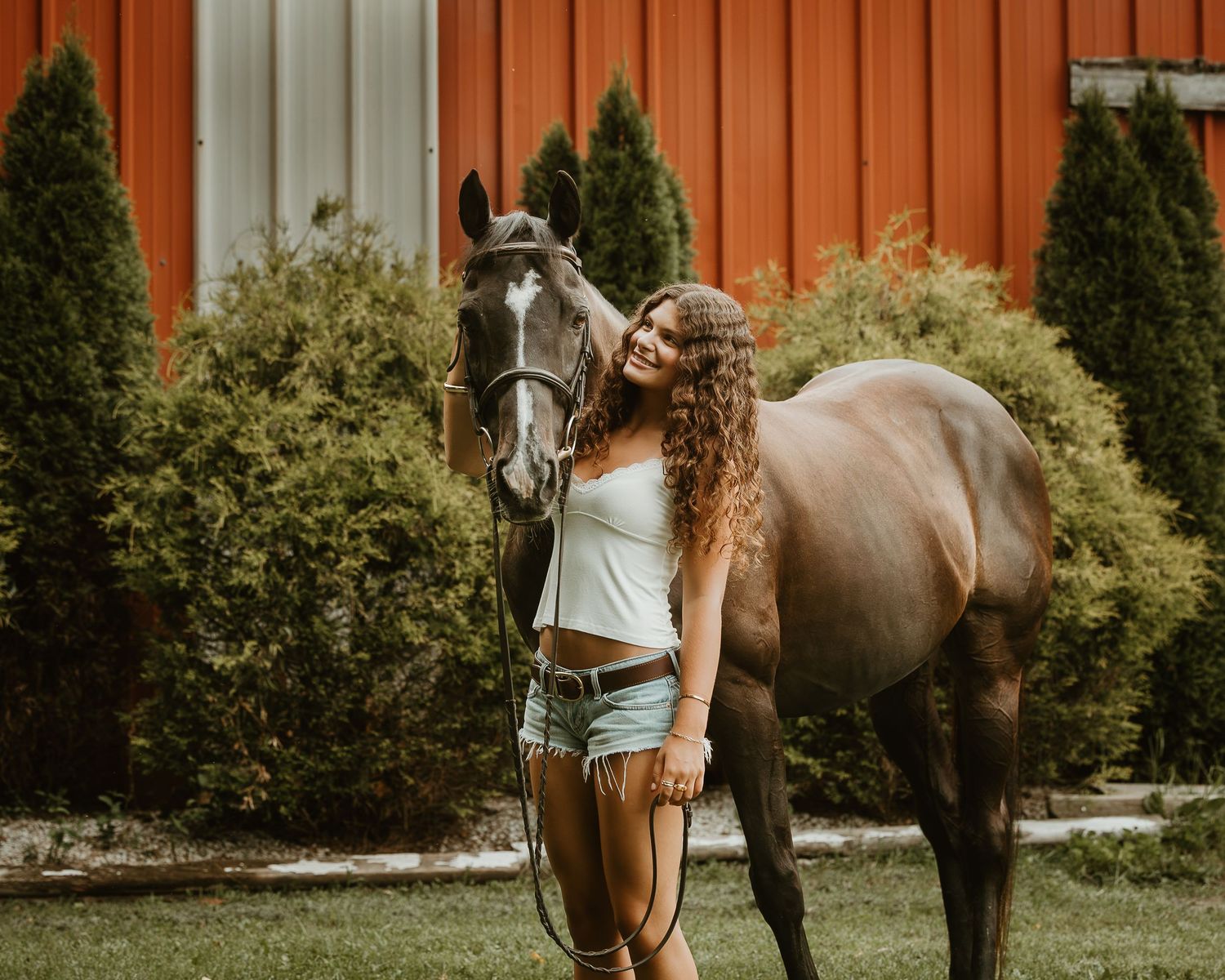 High school senior embracing her dark horse during an outdoor equestrian portrait session in Connecticut