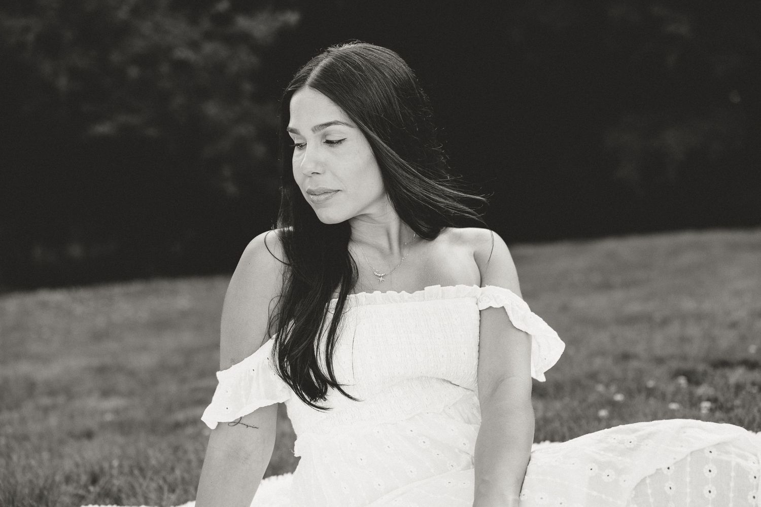 Black and white outdoor portrait of Christina seated on grass, editorial femme photography in Connecticut