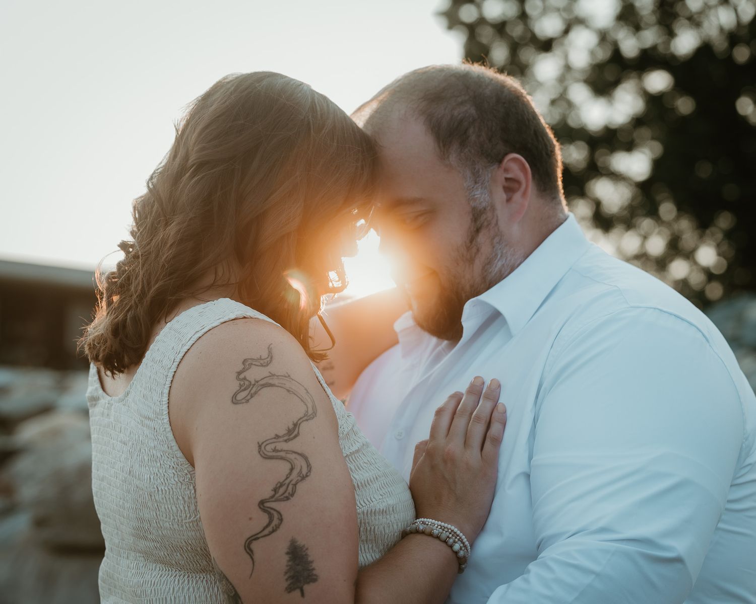 Engaged couple embracing with sunset flare, Walnut Beach Milford CT