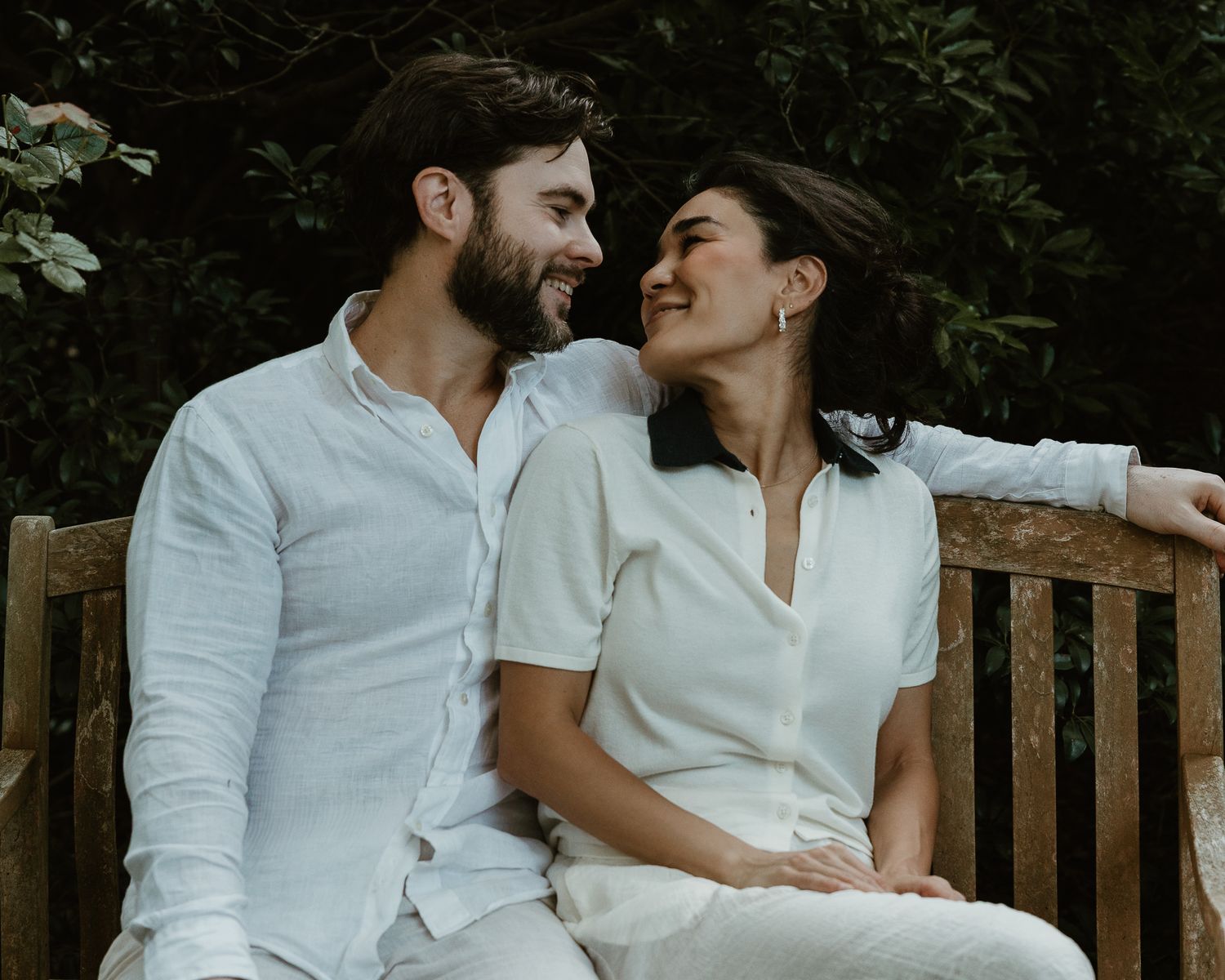 Couple laughing together on a bench, outdoor portrait session in Woodbridge, CT