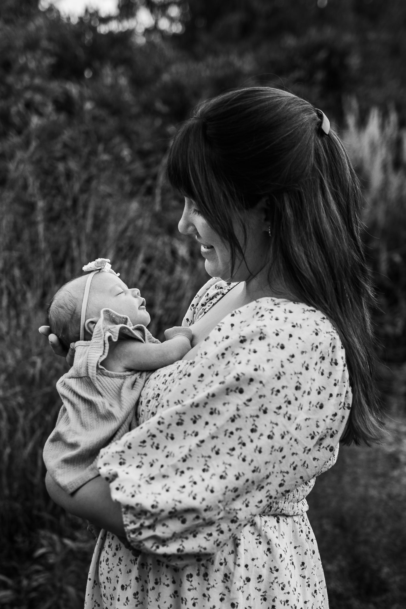 Black and white portraits showing someone holding and cuddling a small baby.