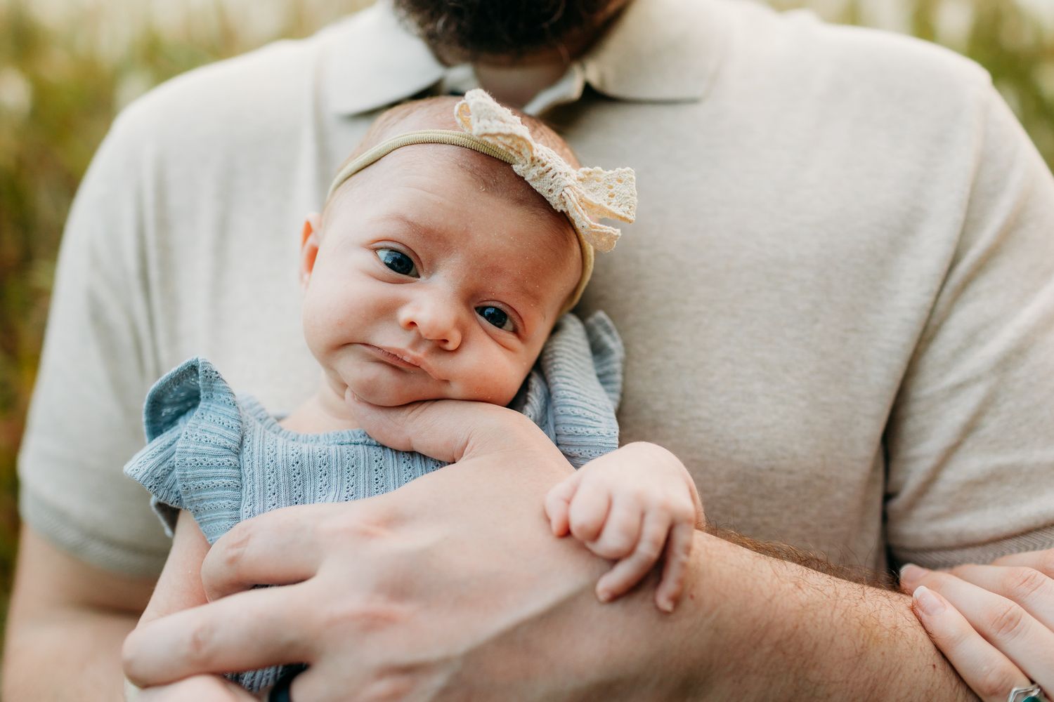 Tender moment captured in outdoor setting with soft natural lighting.