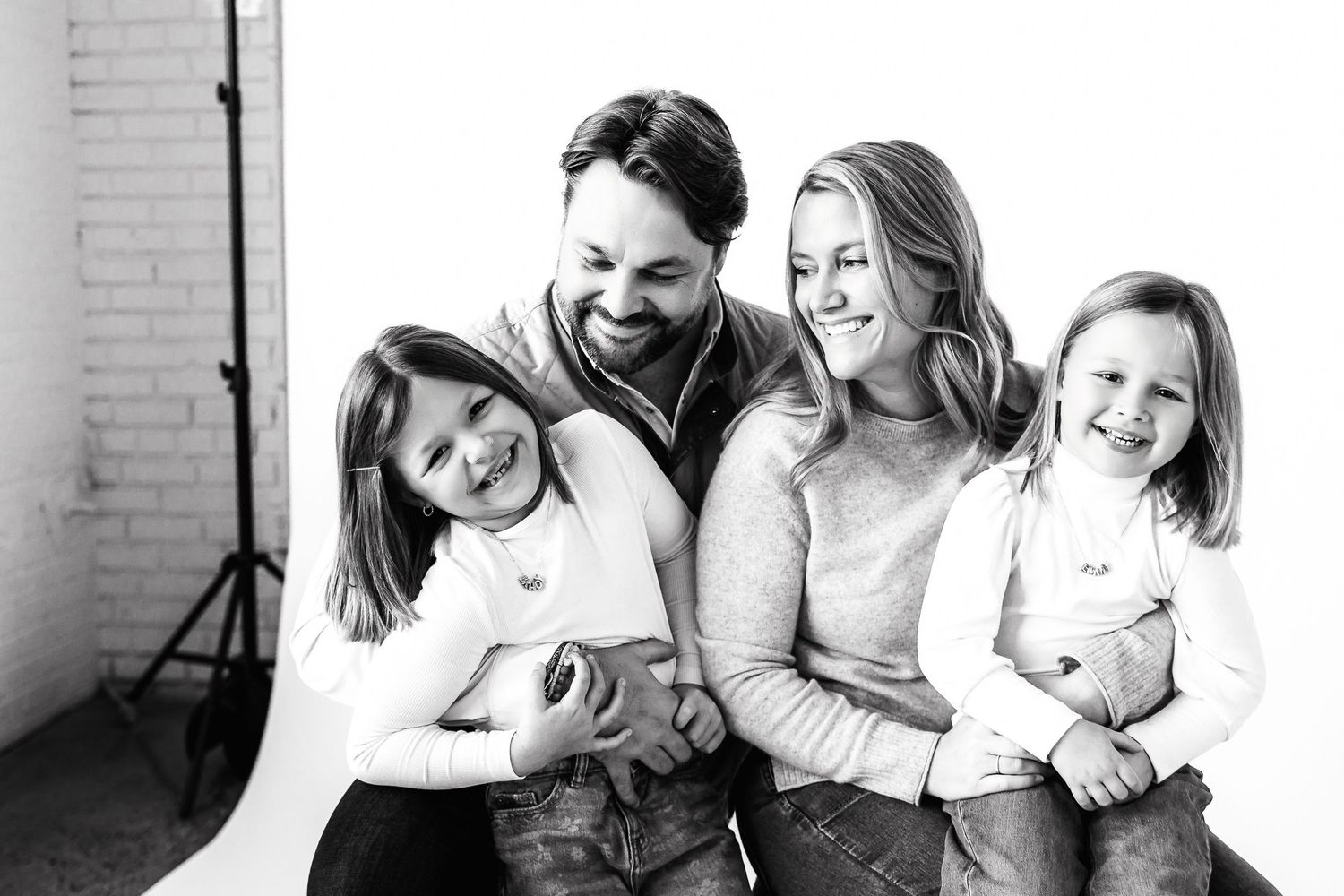 A series of black and white candid family photos showing playful interactions and laughter.