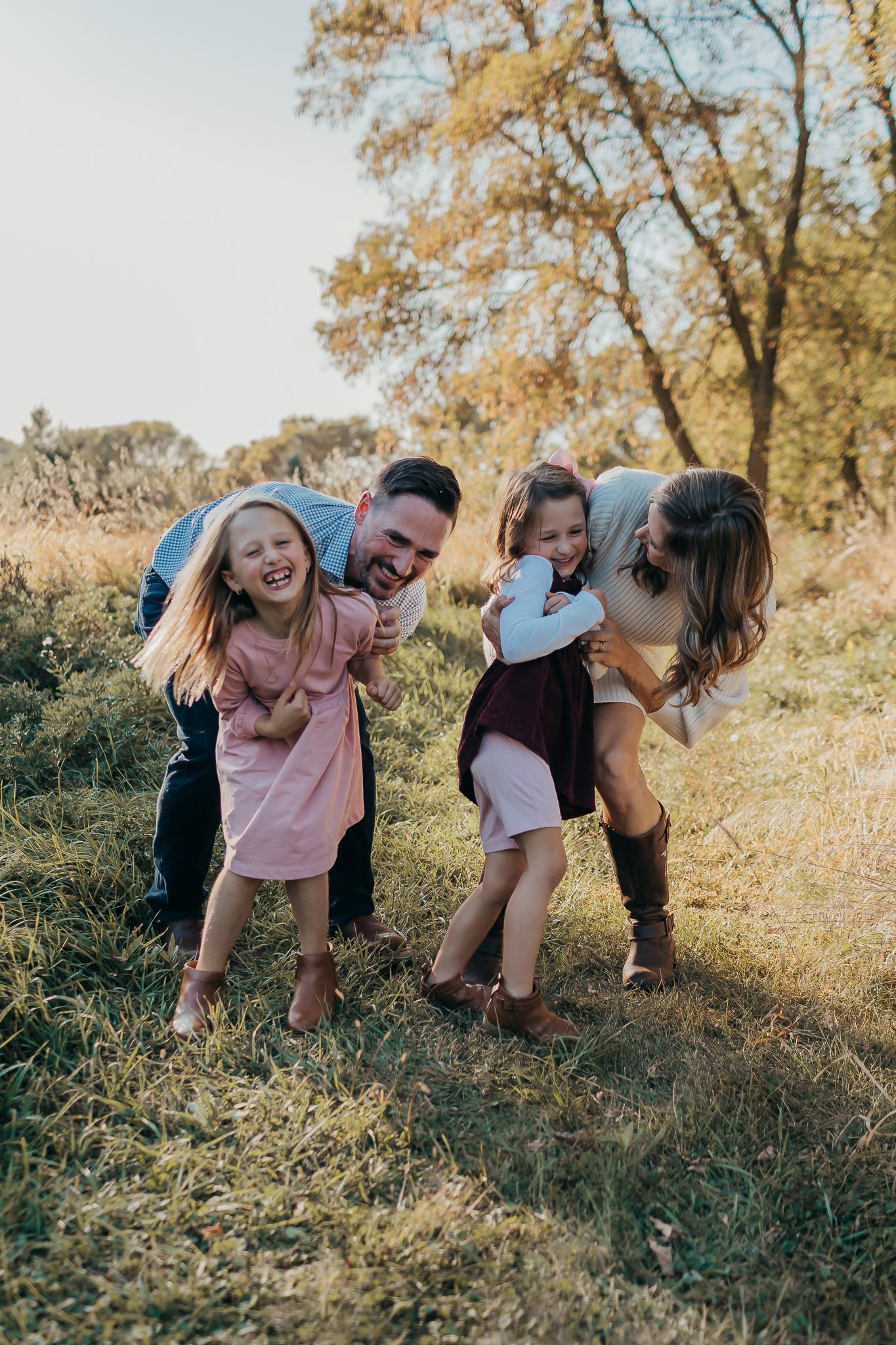A playful family sequence showing everyone bending down together in a sunny outdoor setting.