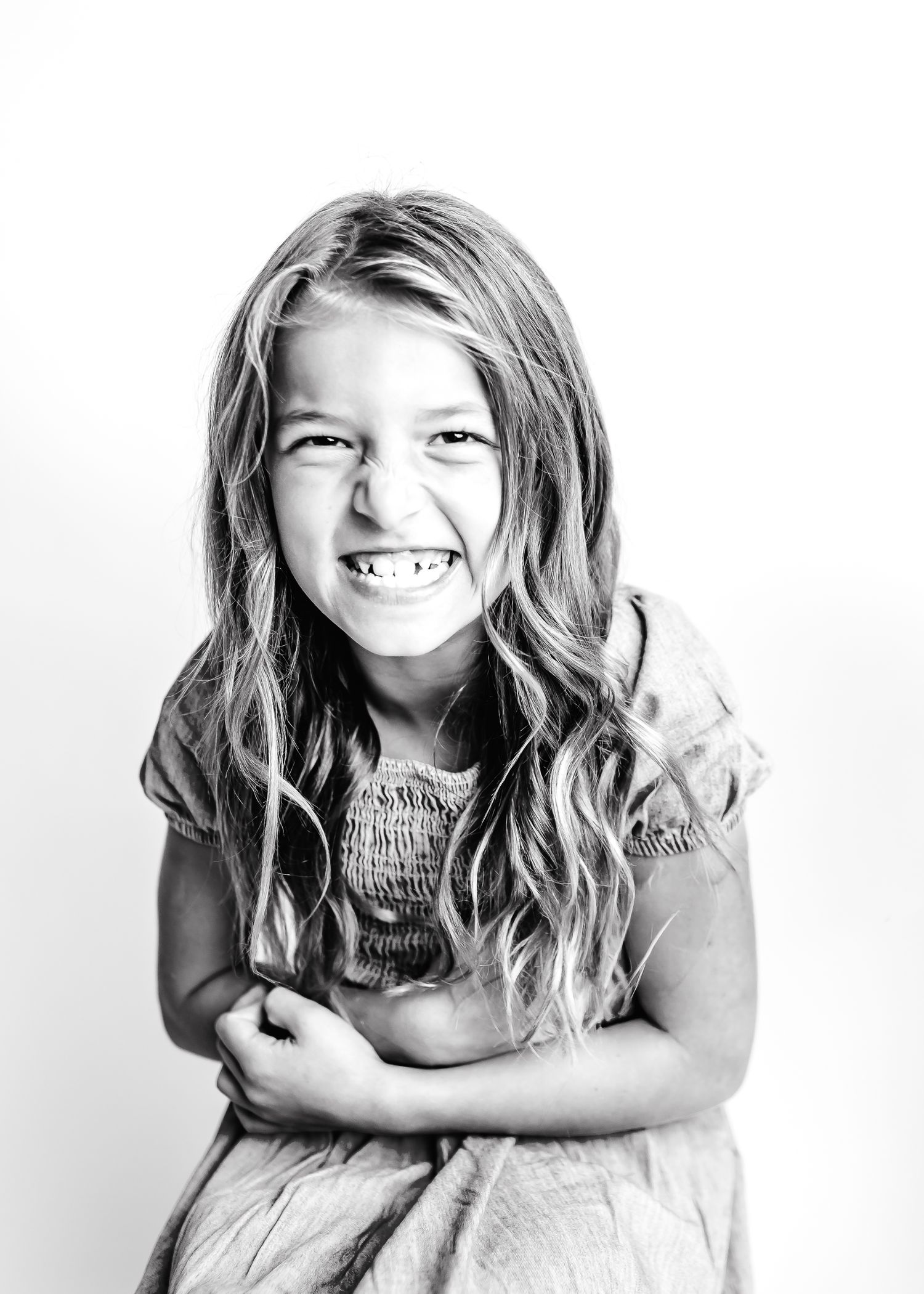 Black and white portrait series showing joyful expressions and wavy hair.