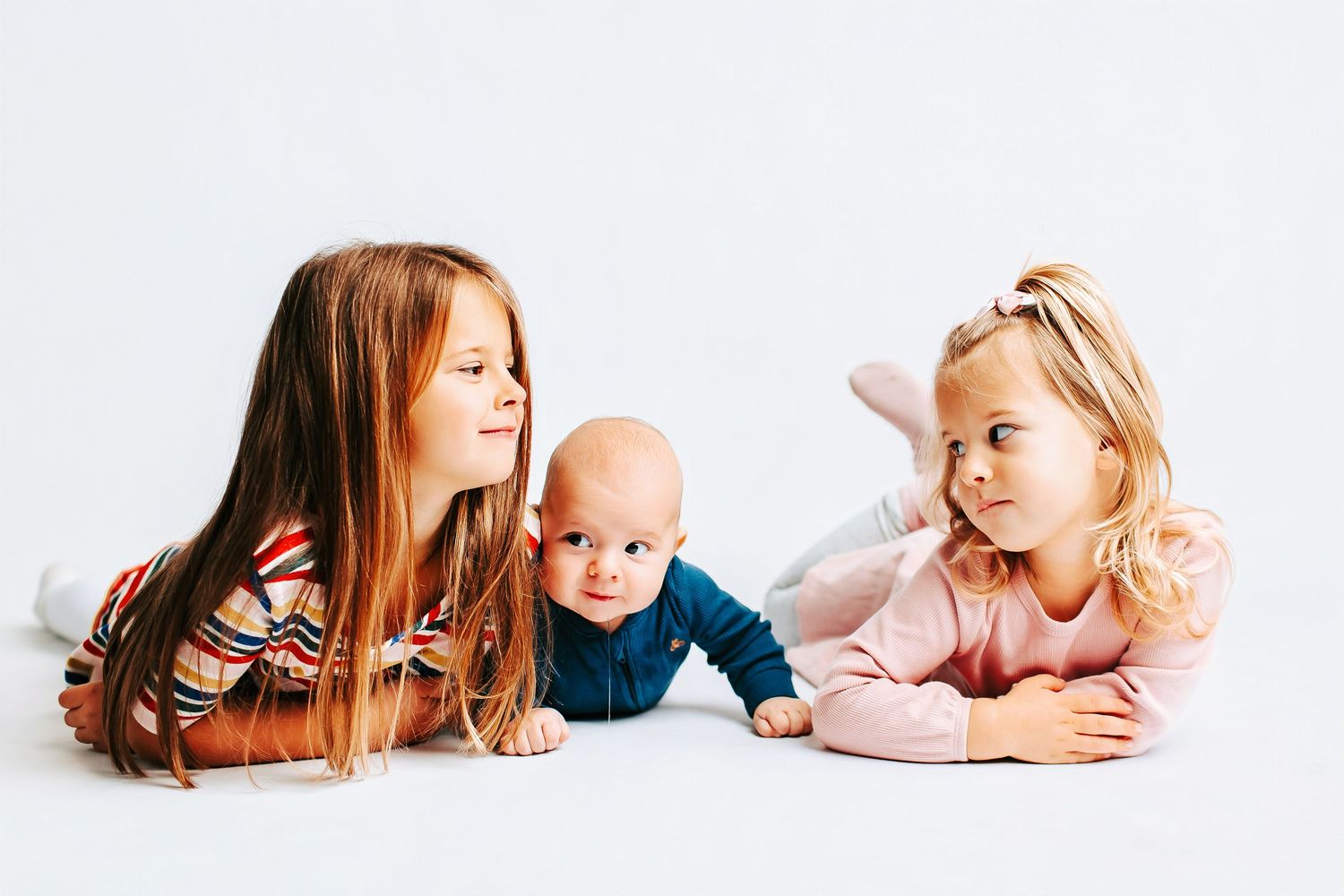 A sweet studio photo series showing tender family moments against a white background.