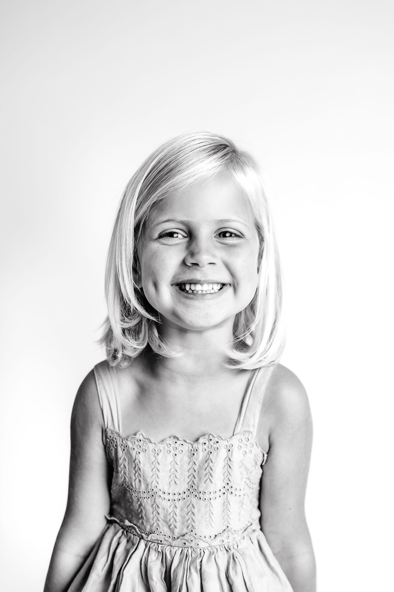 Black and white studio portraits showing joyful expressions in a lace dress.