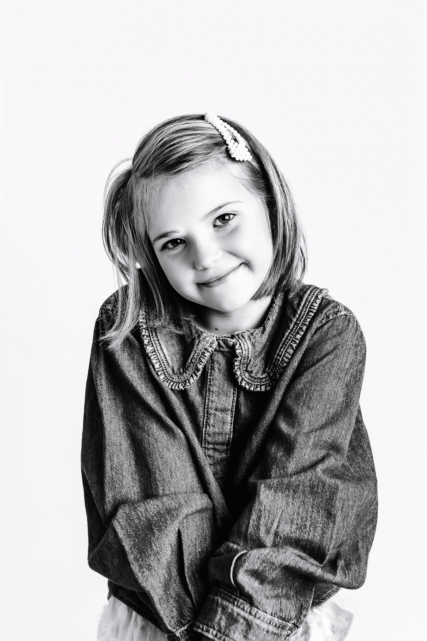Child in denim jacket making expressive poses in black and white photo series.