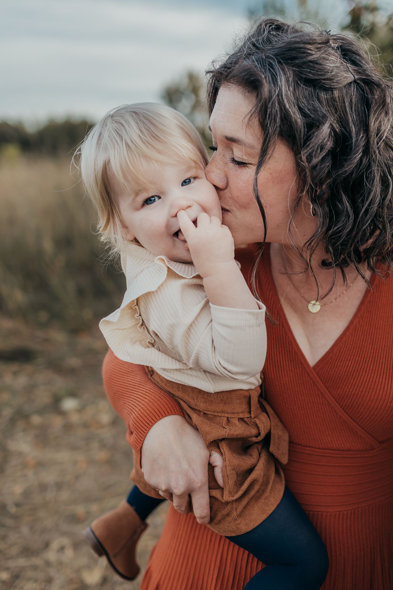 Heartwarming outdoor family moment in autumn colors with rust-colored sweater.